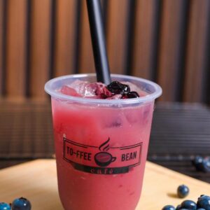 Blueberry soda drink in a plastic cup with fresh blueberries Title