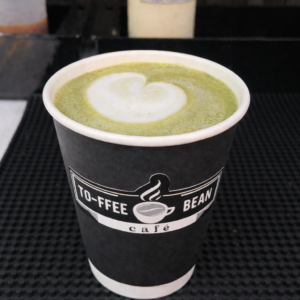 Matcha latte in a cup with creamy milk and green tea powder